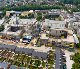 Aerial view of of a big new development, including flats and houses. 