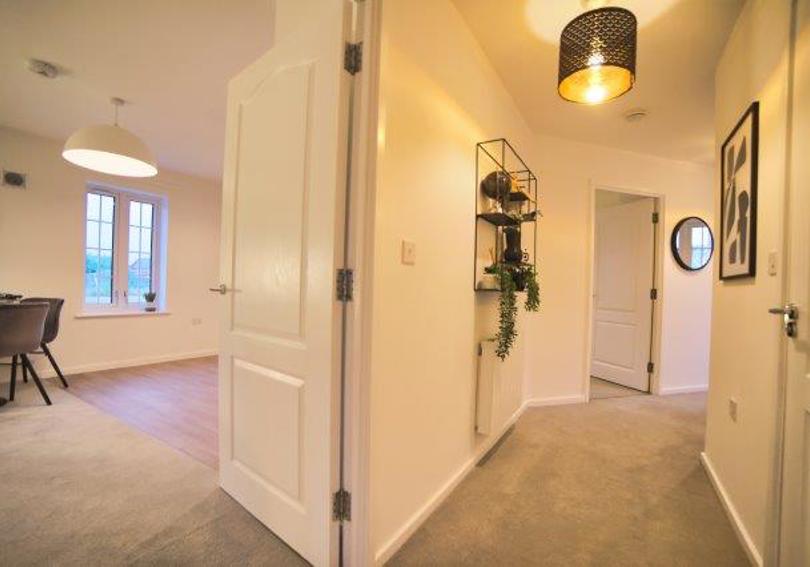 View of the hallway showing the door leading into the kitchen and living area