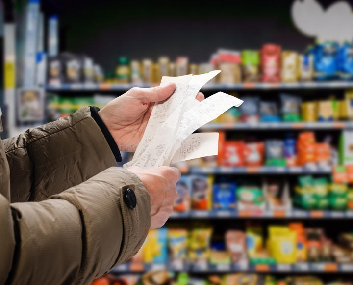 Someone holding a lot of receipts in a supermarket, showing the impact of the cost of living crisis 