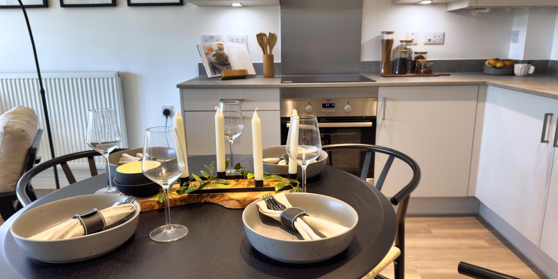 A small circular black table and 4 dining chairs positioned in the kitchen/diner