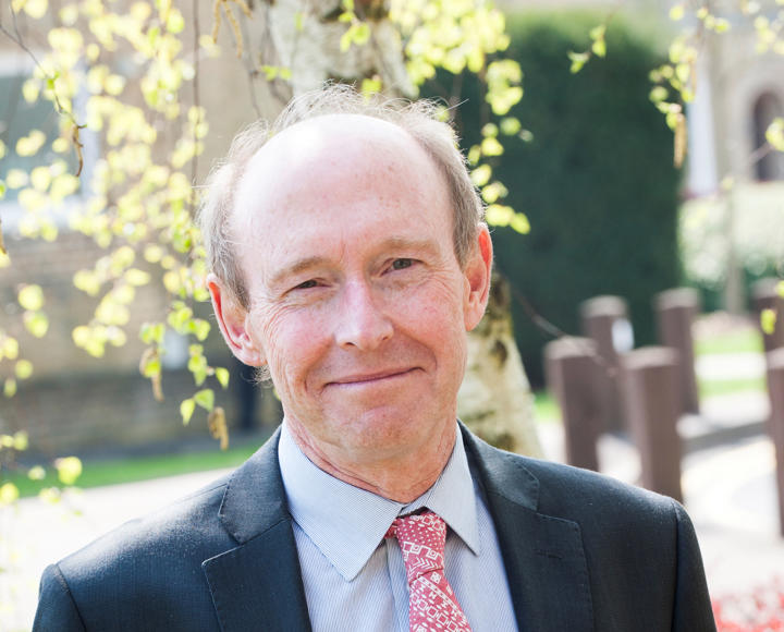 CEO of Hightown. He is wearing a dark grey suit, blue shirt and a red and white patterned tie.