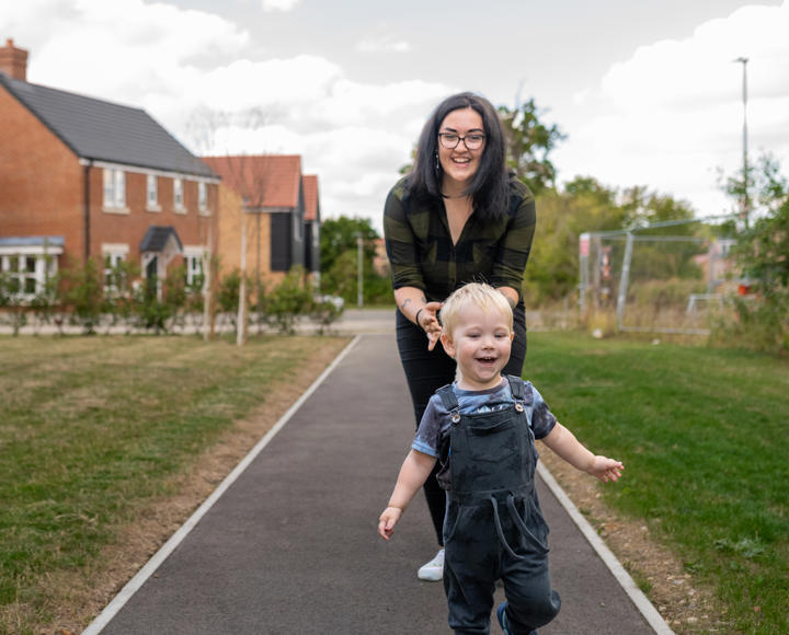 Hightown resident and her son running ahead of her in the outside communal space of a new development