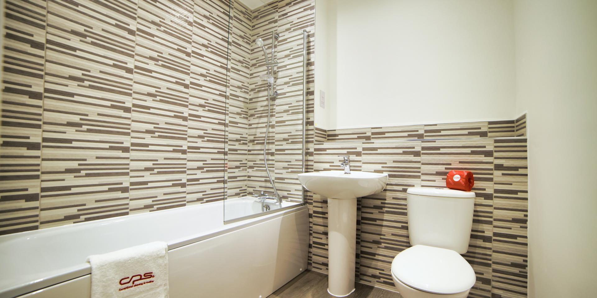 Family bathroom with bath, shower over bath, wash hand basin and toilet