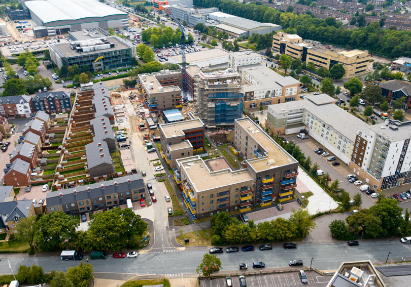 An aerial shot of new build flats and houses. 
