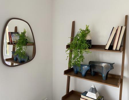 A stock image of a ladder shelving unit with ornaments on it