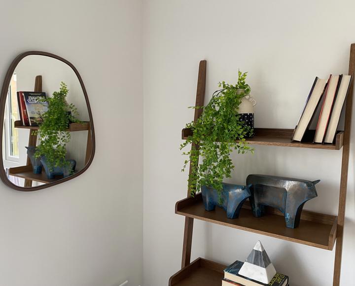 A stock image of a ladder shelving unit with ornaments on it